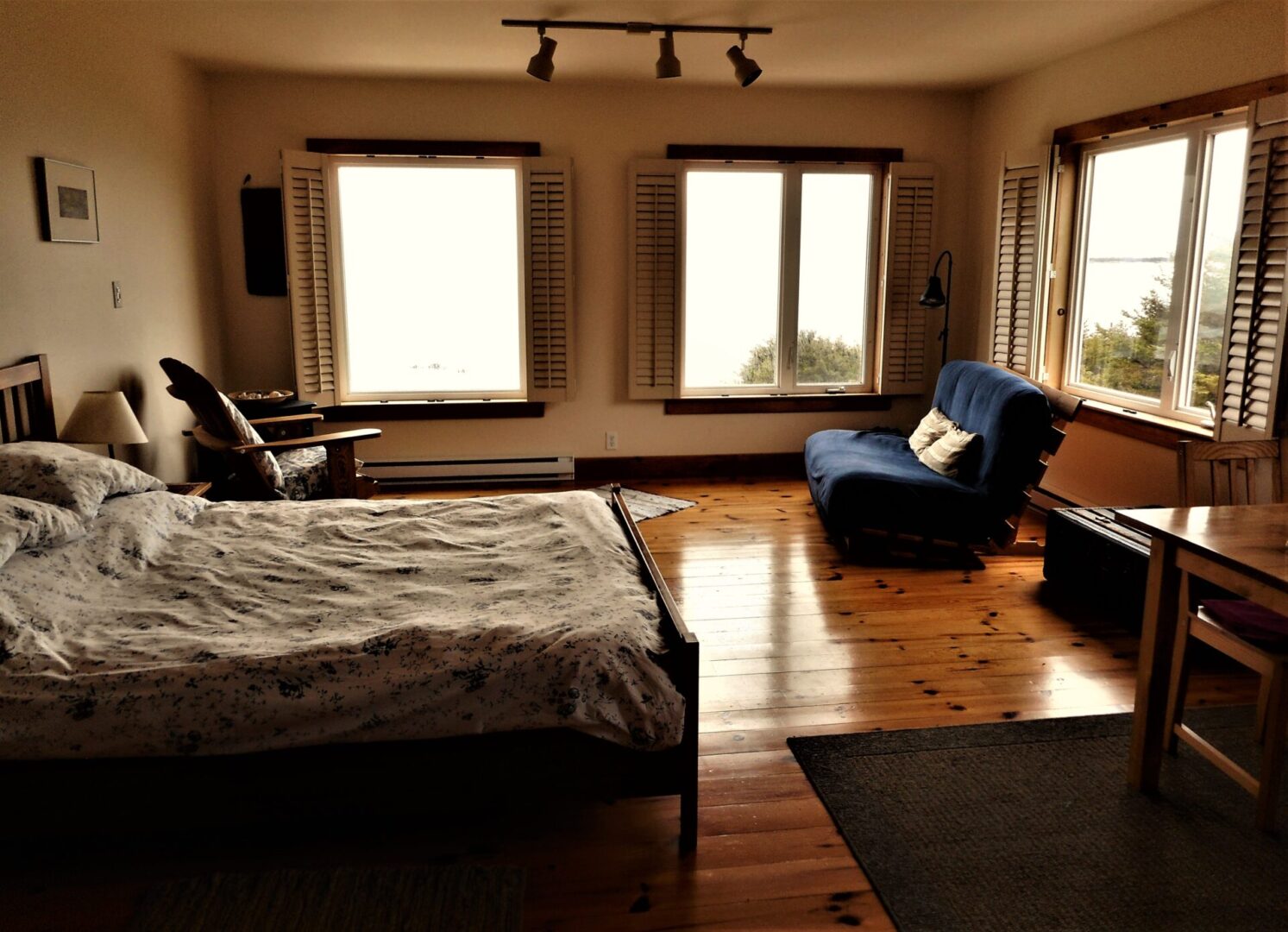 A bedroom with a bed, chair and window.